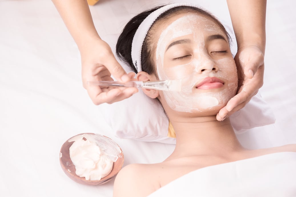 Young girl with facial mask at beauty salon